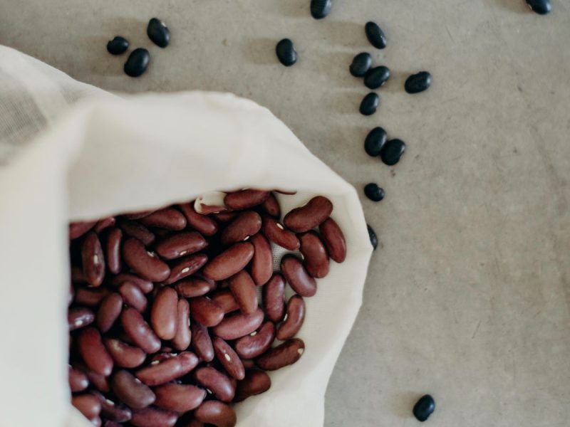 Haricots rouges secs dans un sac à vrac en coton, haricots noirs autour